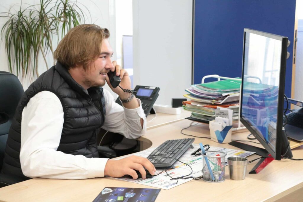 Un collaborateur TPE parle au téléphone, profitant d'un support informatique et téléphonie IP performant