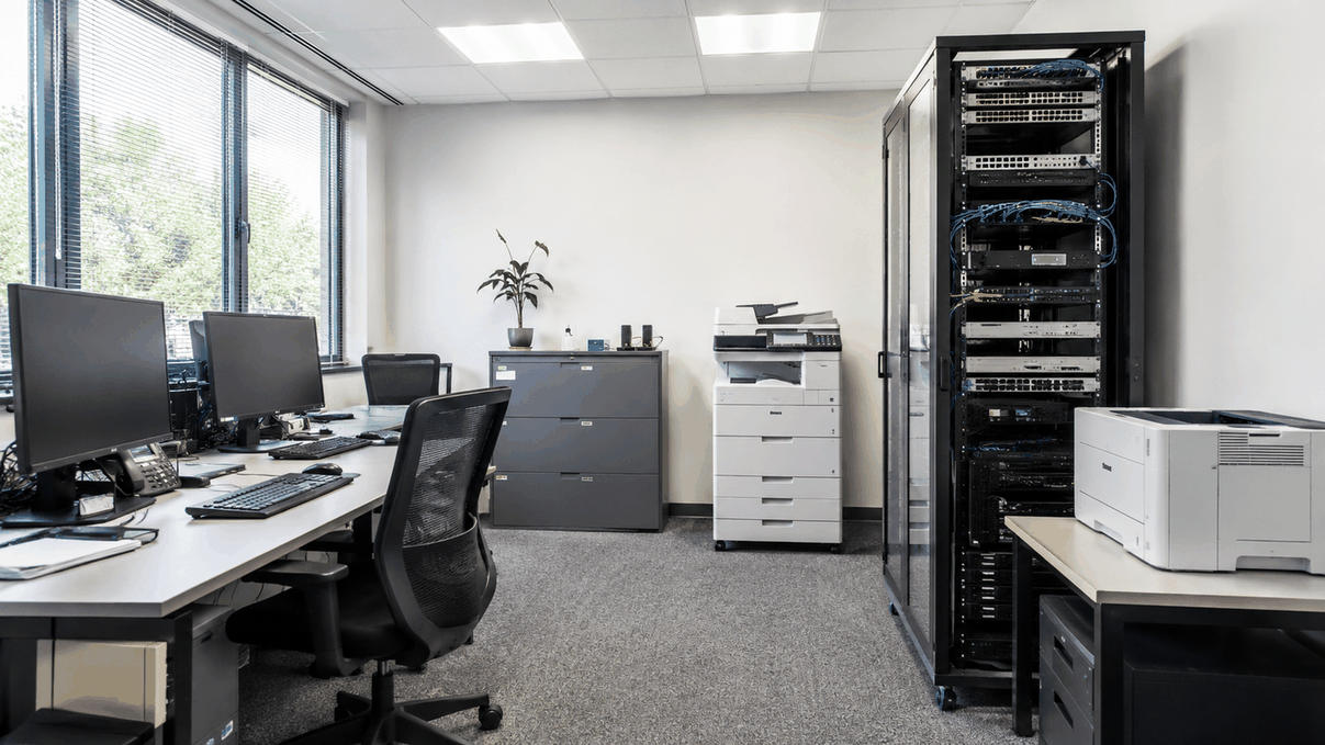 Bureau professionnel équipé d'ordinateurs et d'un serveur réseau, offrant support informatique et connectivité fibre pour TPE et PME