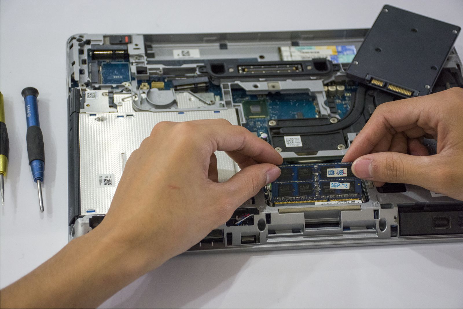Technicien BTR installe une barrette RAM dans un ordinateur portable, offrant support informatique et mise à jour pour TPE et PME