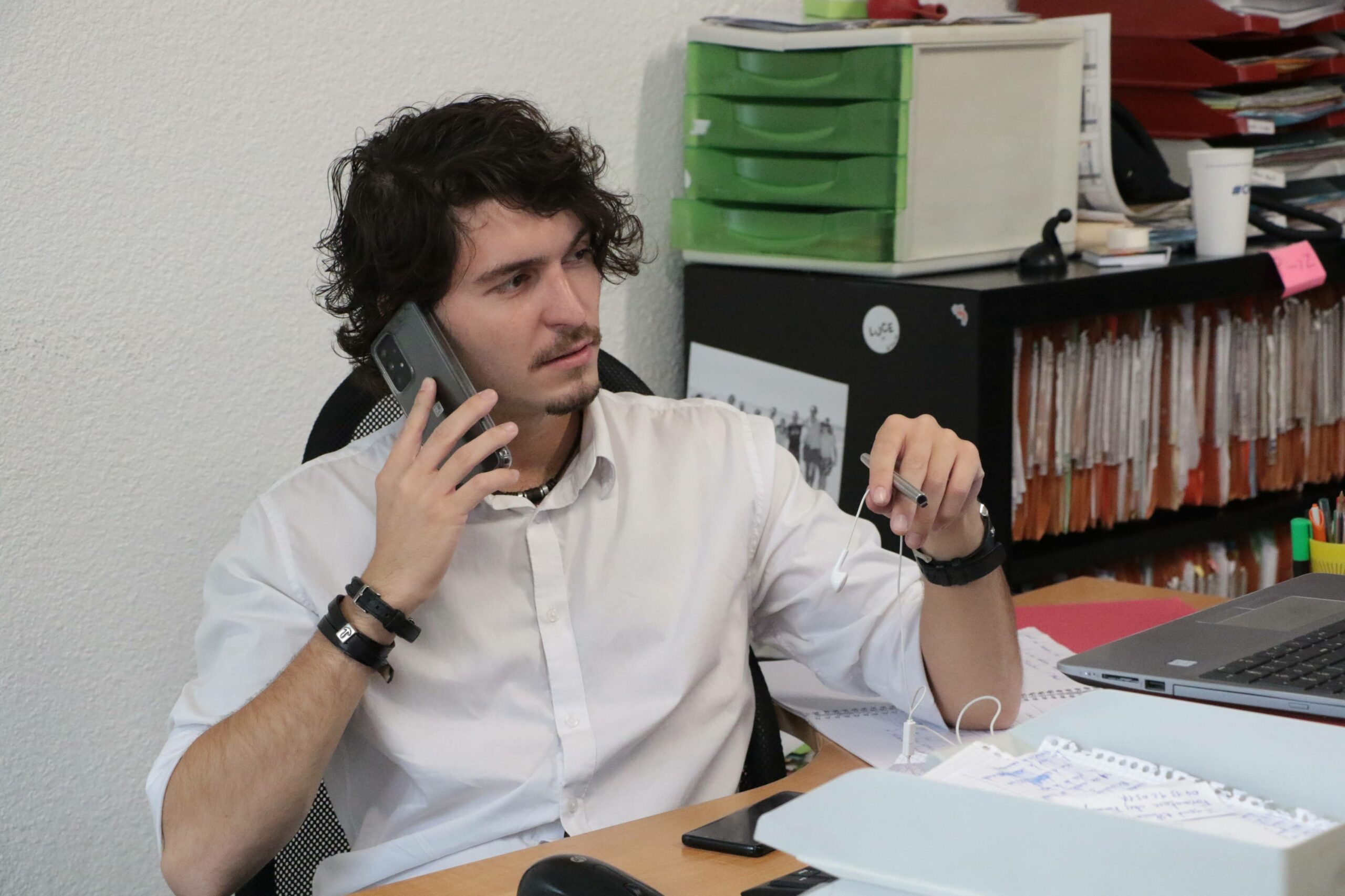 Un professionnel au bureau utilise son téléphone pour un accompagnement téléphonique et informatique adapté aux besoins des TPE et PME